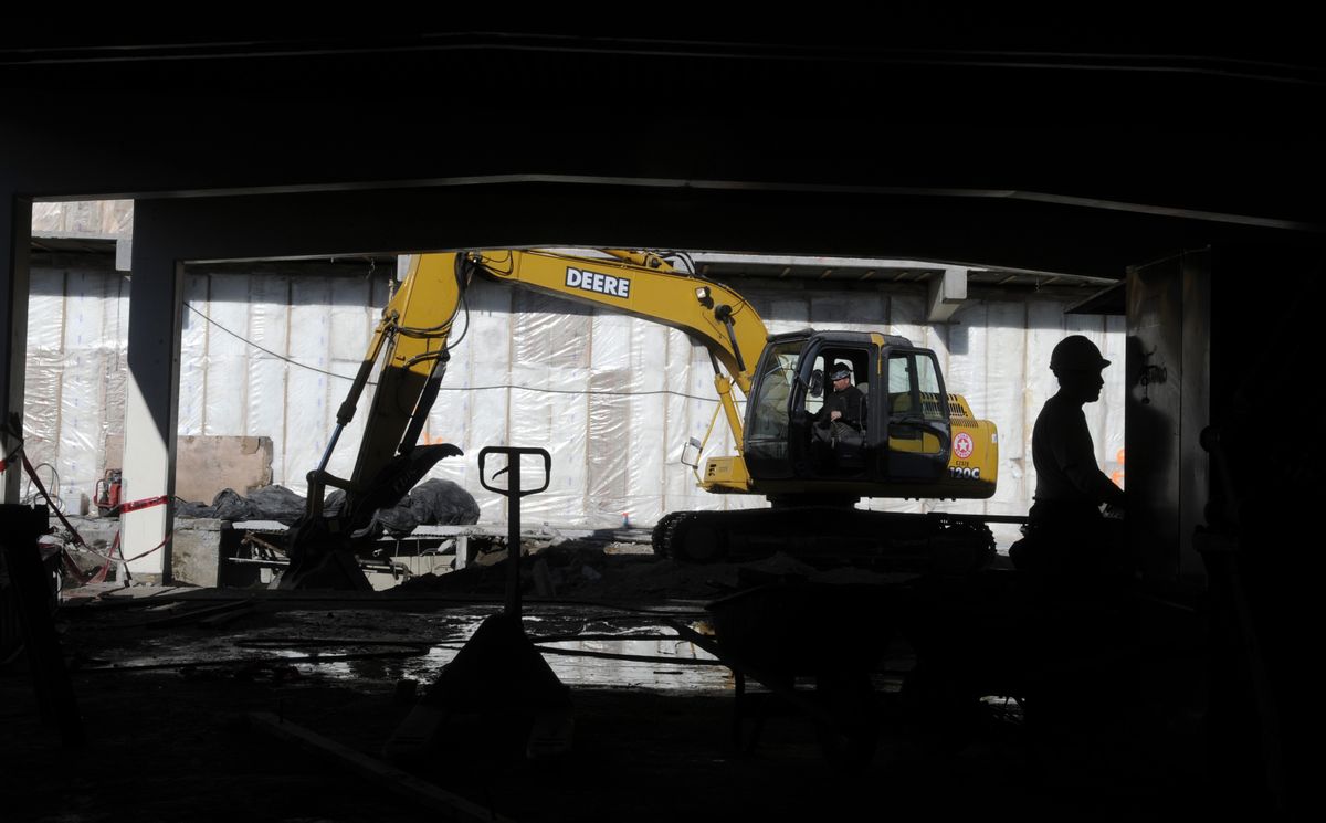 Crews from Talisman Construction Services demolish classrooms on the north side of the Shadle Park High School library Friday.  (Dan Pelle / The Spokesman-Review)