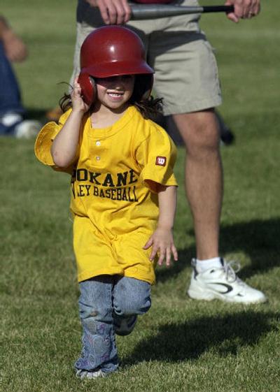 
Destiny Ray, 4, holds onto her helmet as she runs to first base during a game at Pasadena Elementary this week. The Sunrise Yellow Jackets are a part of the Spokane Valley Baseball T-Ball League.
 (Liz Kishimoto / The Spokesman-Review)