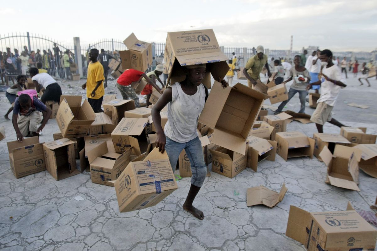 Youths collect empty boxes after a food distribution by the United Nations near Cite Soleil in Port-au-Prince, Haiti, on Saturday. Associated Press photo (Associated Press photo)