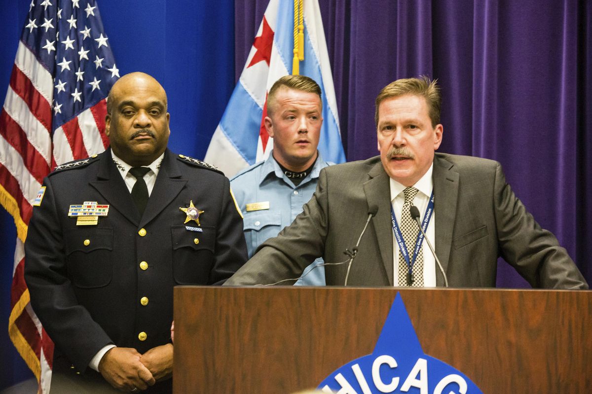 Chicago Police Commander Kevin Duffin, accompanied by Police Superintendent Eddie Johnson, left, and officer Mike Donnelly, rear, speaks during a news conference Thursday about the alleged hate crime and other charges filed against four individuals for an attack on a man that was captured on a Facebook video. (James Foster / Associated Press)