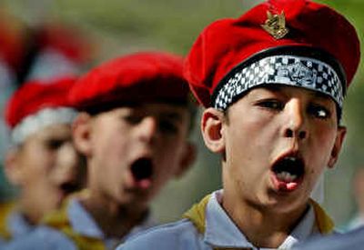 
Palestinian boy scouts chant slogans during a ceremony in support of Palestinian prisoners held in Israeli jails and in memory of Palestinian leader Yasser Arafat in the Qalandia refugee camp, just outside the West Bank town of Ramallah, on Saturday. 
 (Associated Press / The Spokesman-Review)