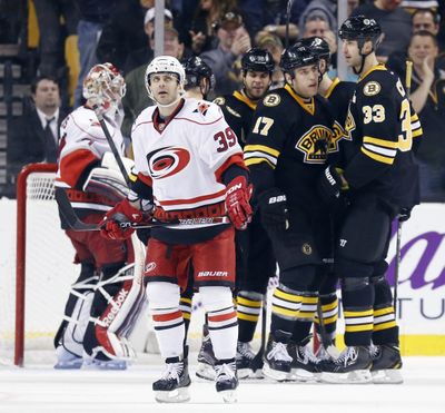 Carolina’s Patrick Dwyer looks toward the scoreboard as the Bruins celebrate a goal in the third period. (Associated Press)