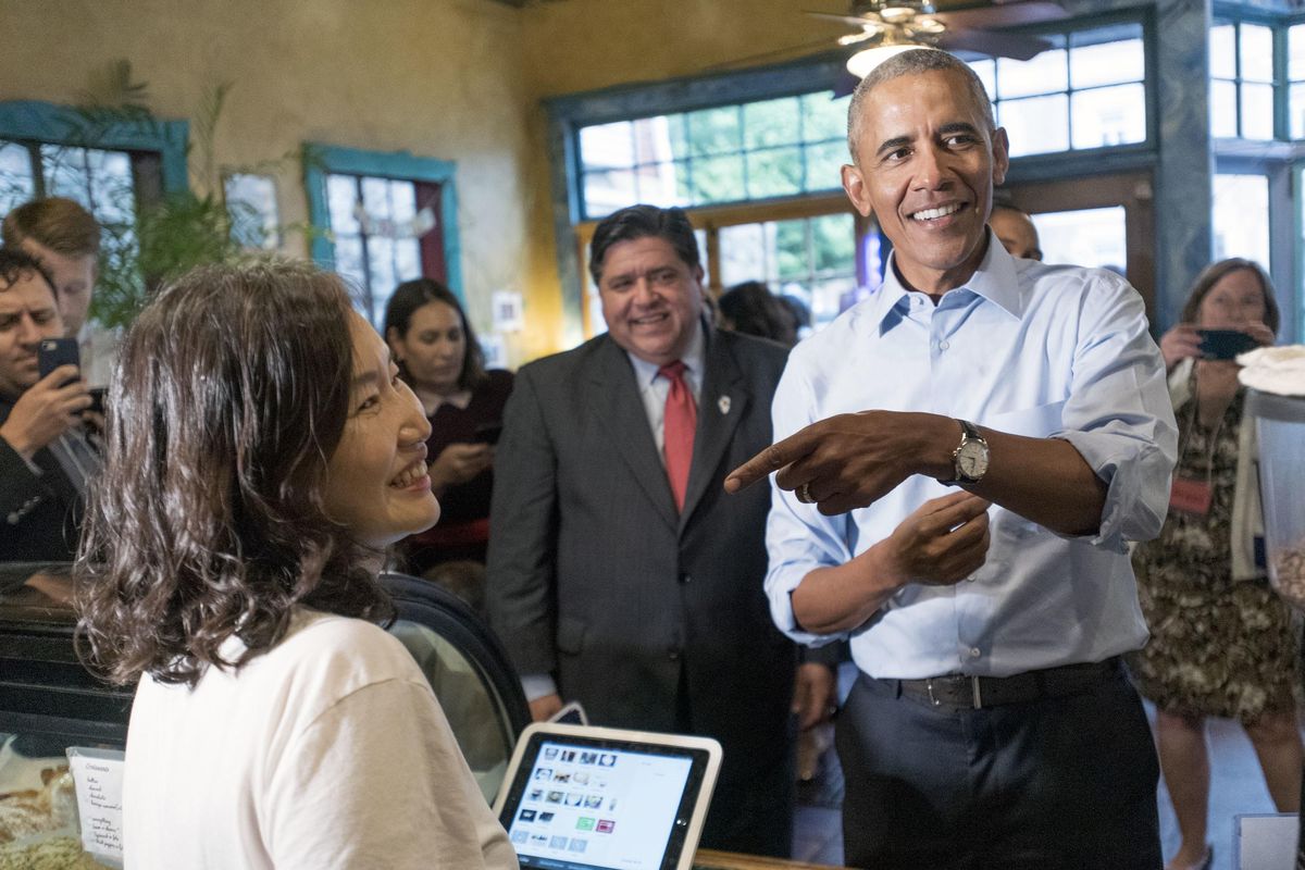 Former President Barack Obama talks with Caffe Paradiso owner Young Jeon during a surprise campaign stop with Illinois Democratic gubernatorial candidate J.B. Pritzker and his running mate, state Rep. Juliana Stratton on Friday, Sept. 7, 2018, after speaking on the University of Illinois campus in Urbana, Ill. (Stephen Haas / The News-Gazette)