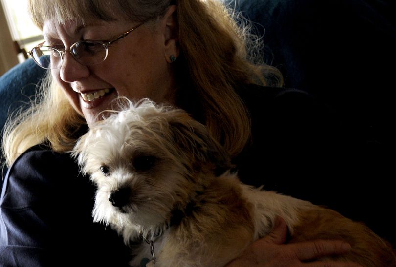 Kathleen Callahan holds her newly adopted dog, Aussie, at her home in Athol on Dec. 10. She lost her dog Paddee to  poisoning in April.  (Kathy Plonka)