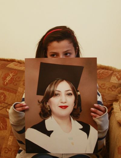 Lilyan, daughter of Palestinian woman Ismat Abdul-Khaleq, a West Bank university lecturer, holds a photograph of her mother at the family house in in the West Bank city of Ramllah, Monday, April 2, 2012.  (Nasser Shiyoukhi / Associated Press)