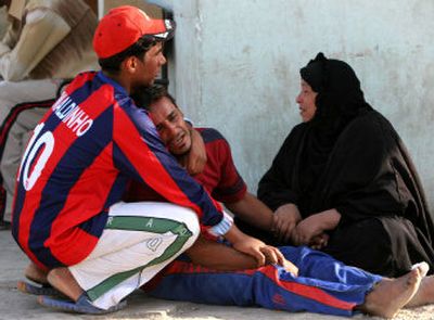 
Relatives of police recruits killed Sunday in an ambush near Baqouba, Iraq, cry as they wait to collect bodies in front of Imam Ali hospital in Baghdad's Shiite enclave of Sadr City on Monday. 
 (Associated Press / The Spokesman-Review)