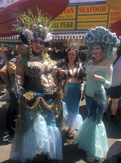 Baltimore's Charm City Tails members Lisa Locklear, left, Kristen Edwards, center, and Rae Beth pose for a photo at New York's Coney Island before the 36th annual Mermaid Parade, Saturday, June 16, 2018. (Julie Walker / Associated Press)