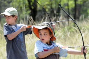 Brothers Grant Cleary, 7, left, and Drew Cleary, 5, wait for the command to fire at the archery station at Sekani Adventure Day on Saturday. (The Spokesman-Review)