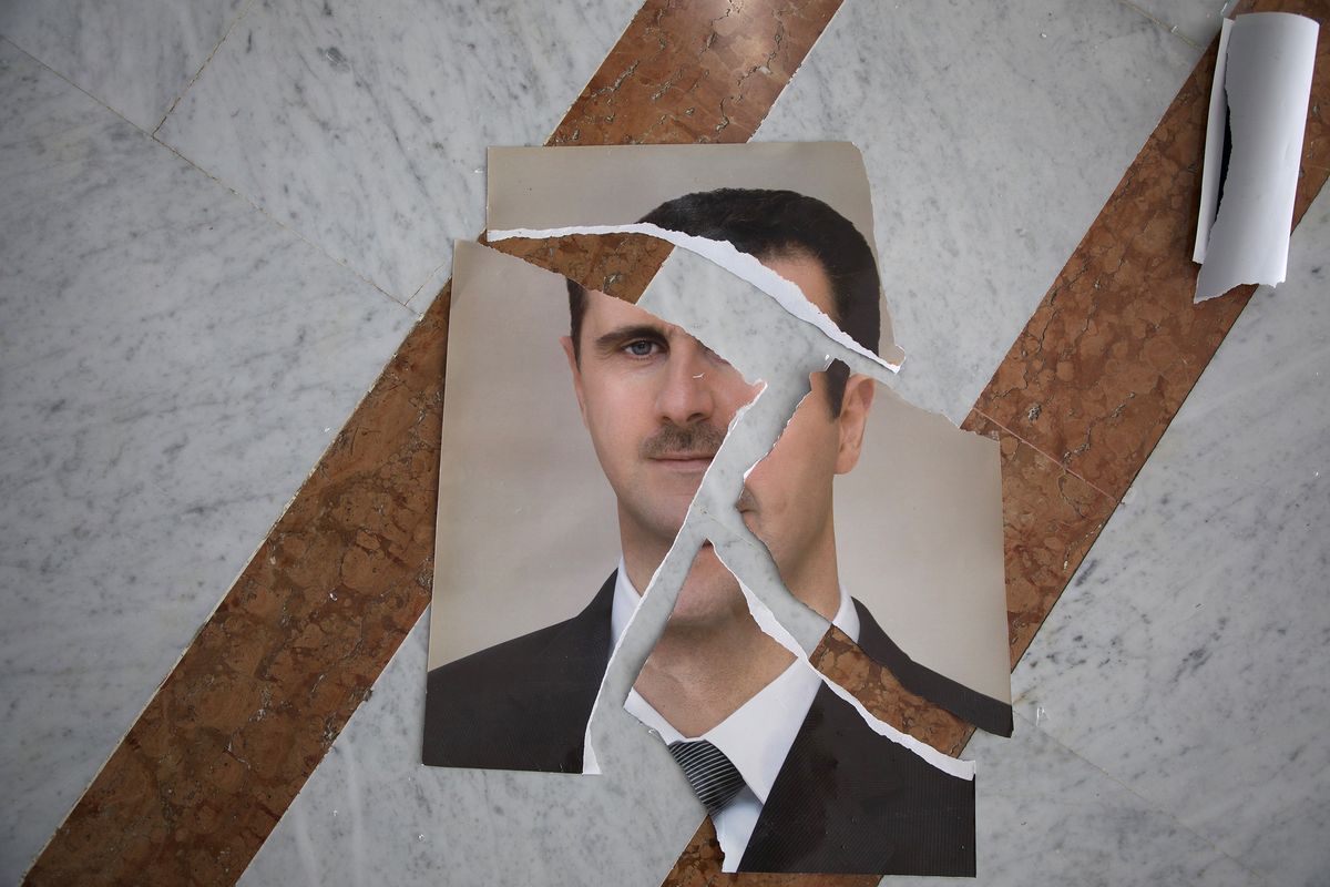 A torn portrait of Bashir Assad that appears to have been arranged is seen inside the Presidential Palace on Dec. 10 in Damascus, Syria.  (Ali Haj Suleiman)