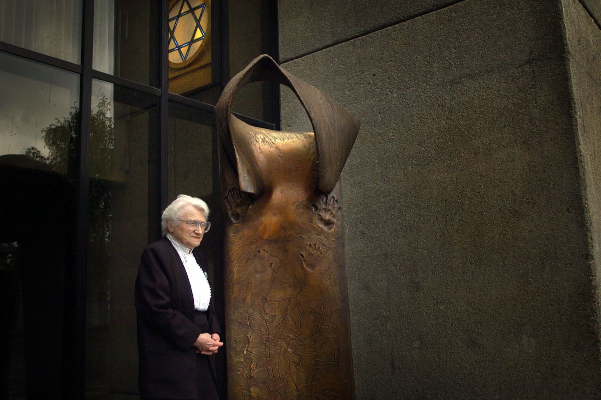 Eva Lassman stands next to the Spokane Community Holocaust Memorial at Temple Beth Shalom in 2005. Lassman, a Holocaust survivor, died in 2011 at 91. She spent the last decades of her life talking to schoolchildren about the Holocaust. In “Eva’s Song,” a poem about her life written by Michael Gurian, Lassman says: “I am a Jew, and Jews were born to plant flowers even in the garden of a thousand sobs.” (File)