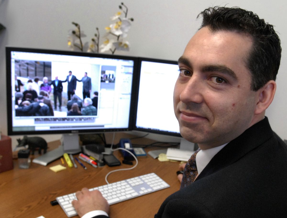 Church communication director Jay Wintermeyer works on photographs from the ribbon cutting of the new temporary headquarters in Spokane Valley.   (J. BART RAYNIAK / The Spokesman-Review)