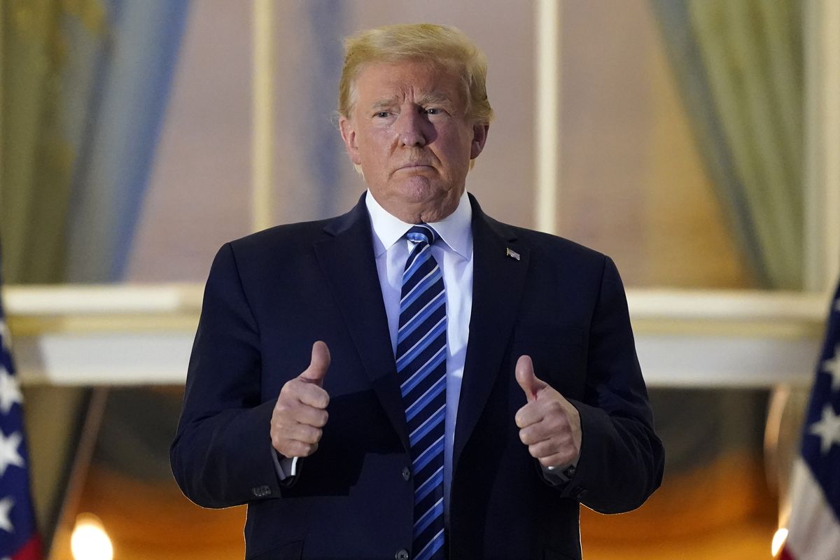 President Donald Trump stands on the balcony outside of the Blue Room as returns to the White House Monday, Oct. 5, 2020, in Washington, after leaving Walter Reed National Military Medical Center, in Bethesda, Md. Trump announced he tested positive for COVID-19 on Oct. 2.  (Alex Brandon)