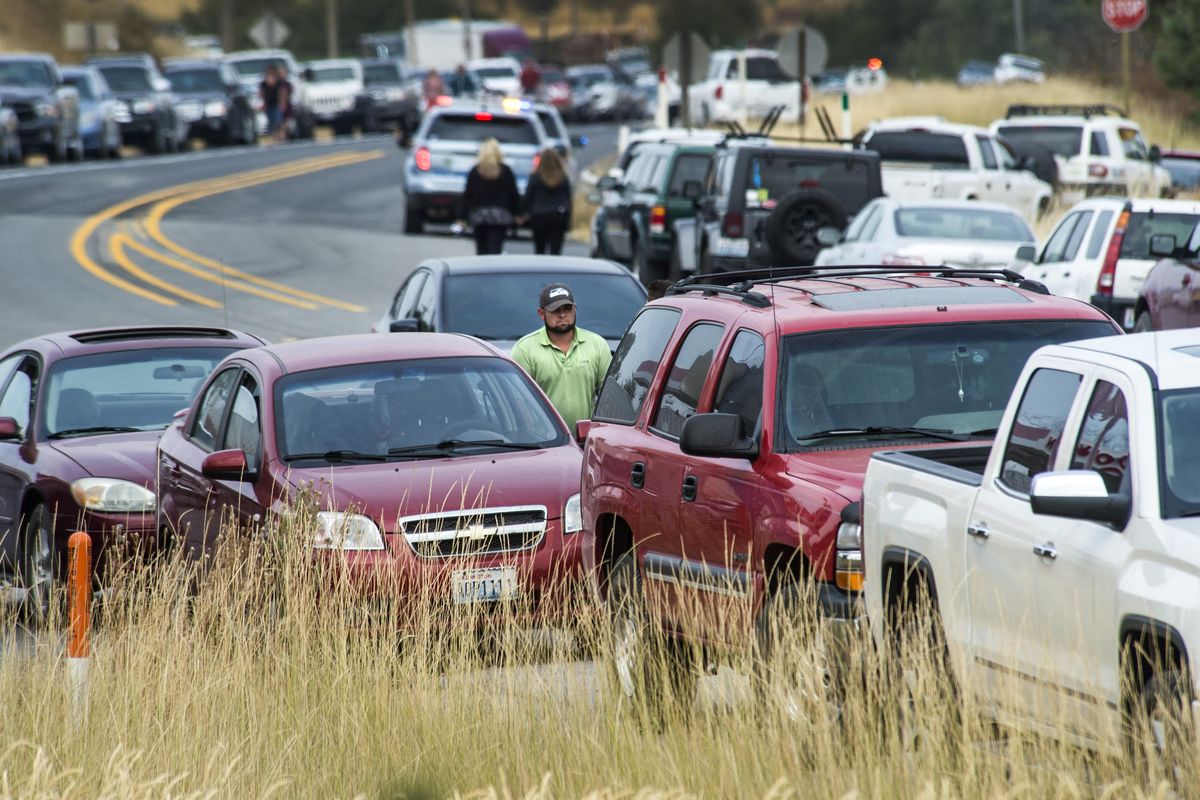 Parents walk along a crowded Highway 27 to get to Freeman High School after a shooting, Sept. 13, 2017. (Dan Pelle / The Spokesman-Review)