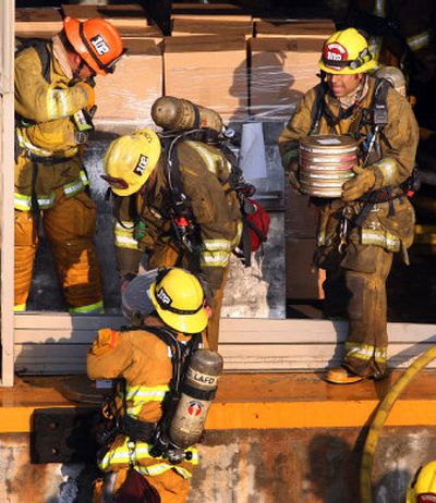 
Firefighters remove film canisters from a burning video vault Sunday at Universal Studios. Associated Press
 (Associated Press / The Spokesman-Review)
