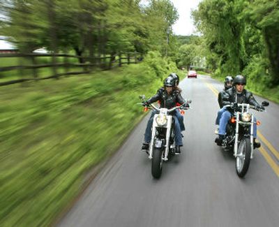 
Kari Schwear, left, and her husband, Rob, ride their Harley-Davidson motorcycles with sons Nick, left rear, and Nathan near their Oley, Pa., home in May. Eight months after renting motorcycles, the Schwears bought two bikes.
 (Associated Press / The Spokesman-Review)