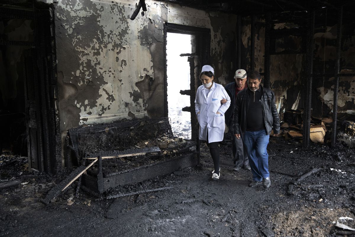 People walk inside a building, destroyed by shelling by Armenian forces in Barda, Azerbaijan, Monday, Oct. 5, 2020. The fighting between Armenian and Azerbaijani forces over the separatist territory of Nagorno-Karabakh resumed Monday, with both sides accusing each other of launching attacks. The region lies in Azerbaijan but has been under the control of ethnic Armenian forces backed by Armenia since the end of a separatist war in 1994. (SUB)