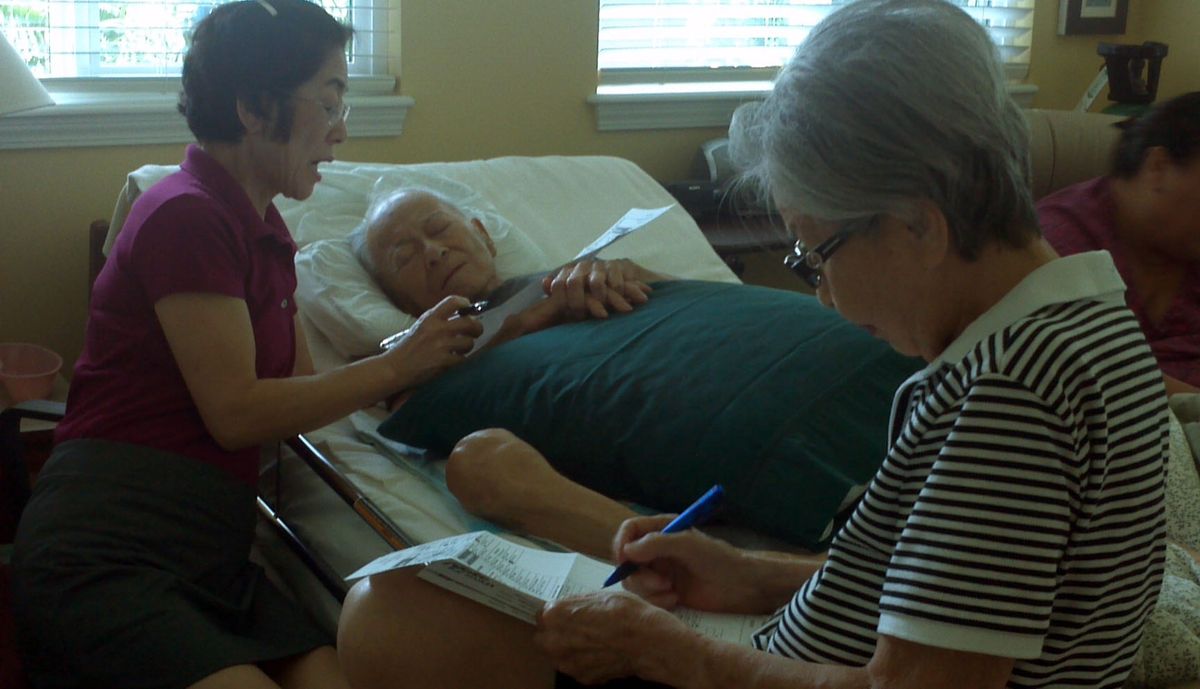 In this Oct. 17, 2012 photo provided by Irene Tanabe, Frank Tanabe, center, gets help from his daughter Barbara Tanabe, left, to fill out his absentee ballot in Honolulu while his wife Setsuko Tanabe sits in the foreground. The photo of the 93-year-old World War II veteran casting what will likely be his last ballot has captured the hearts of tens of thousands of Internet users. (Irene Tanabe / Irene Tanabe)