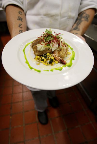 Commander’s Palace cook Ryan Andre holds a “King of Seafood” plate Friday in New Orleans.  (Associated Press)