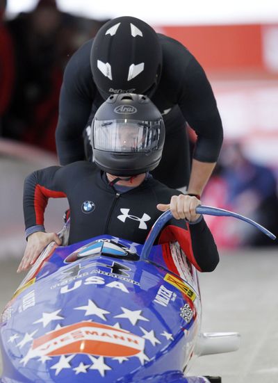 U.S. driver John Napier sits in front of his two-man bobsled. He returned from a deployment in Afghanistan last month.  (Associated Press)