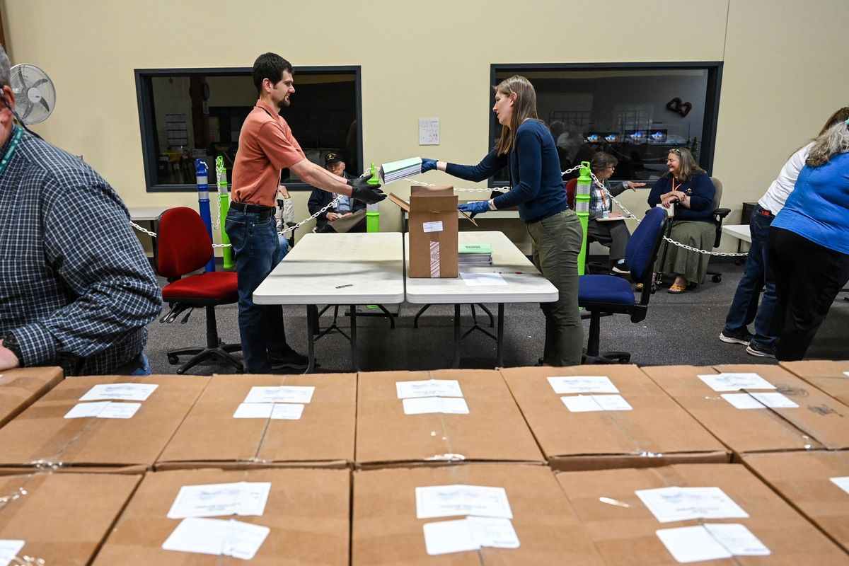 Ryan Dosch, left, and Amelia Odeen, of the Spokane County Elections Office, handle special elections ballots during a recount request by citizens of a Cheney precinct’s votes on Tuesday.  (DAN PELLE/THE SPOKESMAN-REVIEW)