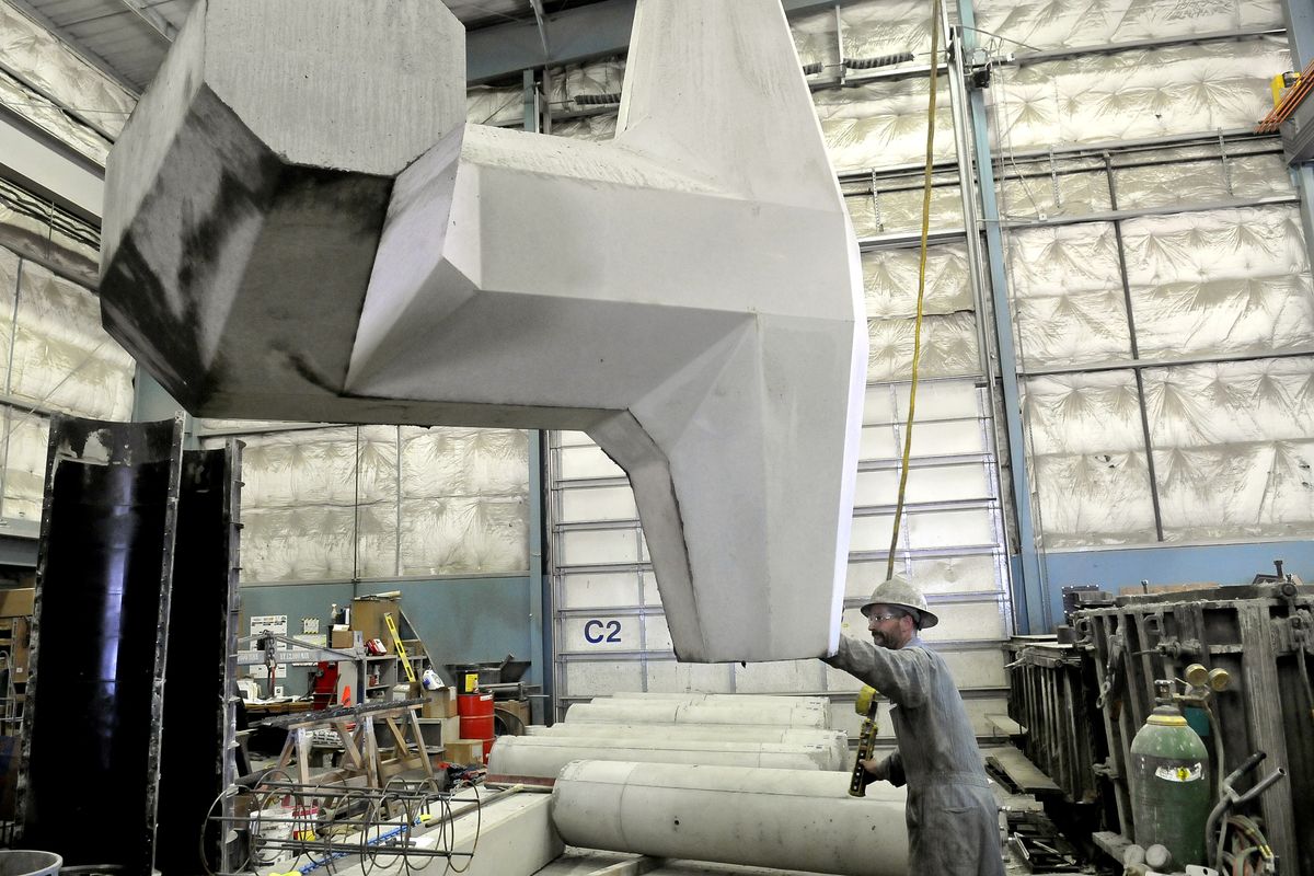 Steve Gregerson uses a crane to move an 8-ton concrete dolo that had just been cast at Wilbert Precast on Monday. (Jesse Tinsley)