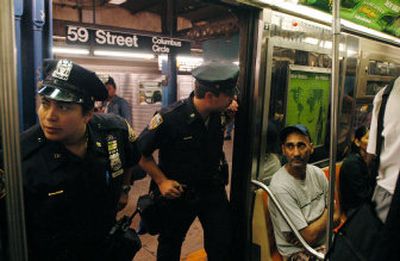 
New York City police officers check subway cars at Columbus Circle on Oct. 7 after the announcement of a specific terrorist threat to the subway system. Since then, authorities have said the threat was likely a case of bad information.
 (Associated Press / The Spokesman-Review)