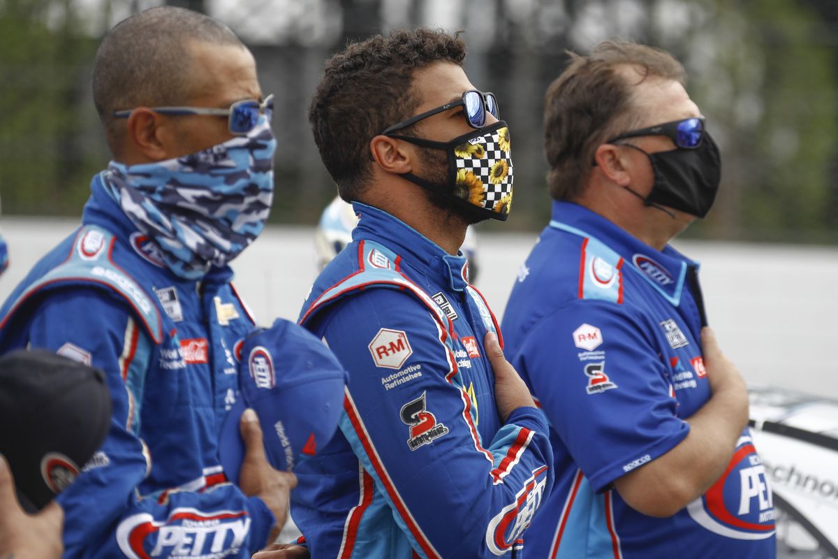 Bubba Wallace, center, stands with his crew during the playing of the national anthem before a scheduled NASCAR Cup Series auto race at Pocono Raceway, Saturday, June 27, 2020, in Long Pond, Pa. (Associated Press)