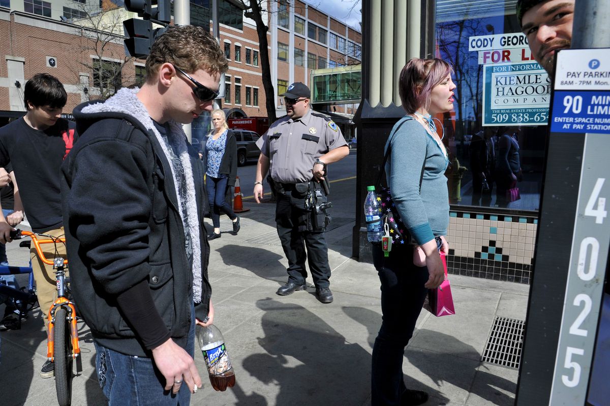 Scott Ellsworth, of Phoenix Protective Corp., keeps smokers away from doorways and prevents people from clogging the middle of the sidewalk at the corner of Riverside Avenue and Post Street in downtown Spokane. (Dan Pelle)