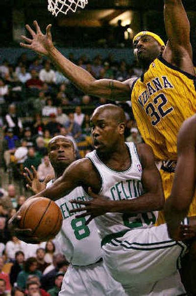 
Gary Payton dumps off the ball to Antoine Walker when he finds his path blocked by Indiana's Dale Davis (32). 
 (Associated Press / The Spokesman-Review)