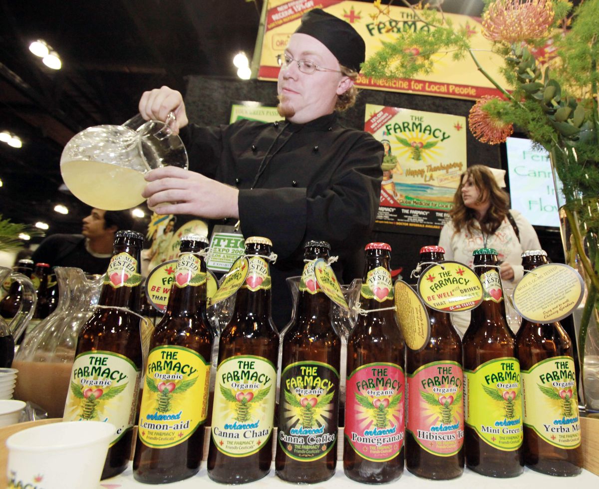 Patrick Zimmerman stands behind a display of the many flavors of drinks available at the Farmacy, as he pours a blend of lemon and cranberry infused with cannabis, or marijuana, at the apothecary’s booth at the THC Expo in Los Angeles. (The Spokesman-Review)