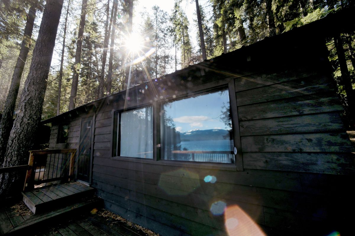 A reflection of Priest Lake is photographed in the window of cabin 108 at Hill