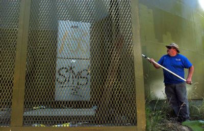 
Dion Holton, an employee of the City of Coeur d'Alene's Water Department, helps repaint a large water tank on Tubbs Hill on Aug. 2. 
 (Jesse Tinsley / The Spokesman-Review)