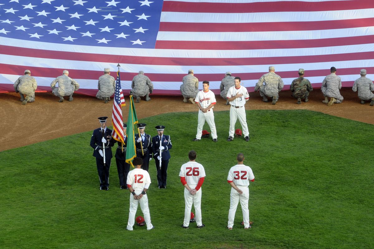Members of the 336th Survival Training Squadron from Fairchild unfurl the large flag while the Honor Guard from the 141st Air Fueling Wing present the colors. (The Spokesman-Review)