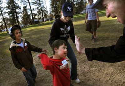 
Michael Van Gordon, 6, gets a high five from Tom Riley as he runs accross home plate with his mom Angela during Challenger Little League practice at Webster Park in Spokane.
 (The Spokesman-Review)