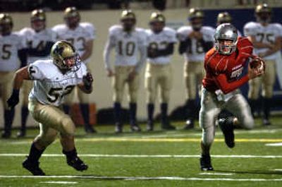 
Ferris QB Jeff Minnerly looks for a way out of trouble as Mead's Anthony Hattrup gives pursuit. 
 (Holly Pickett / The Spokesman-Review)