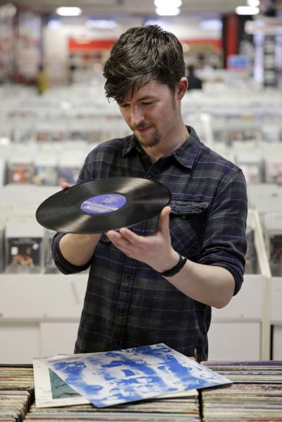 Josh Kelly checks the condition of a used LP record as he puts it in a sales bin Tuesday at Vintage Vinyl Records in Fords, N.J. A recent Rutgers graduate, Kelly is working at the store while he tries to land a job in journalism or radio programming. (Associated Press)