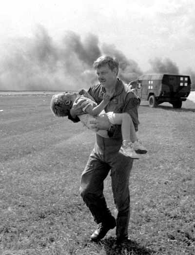 Guardsman Dennis Nielsen carries passenger Spencer Bailey away from the wreckage of United Airlines Flight 232 after the plane crashed at Sioux Gateway Airport on July 19, 1989, in Sioux City, Iowa. (Gary Anderson / Sioux City Journal)