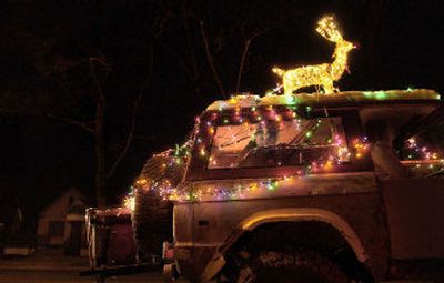 
Matt Holman of the North Idaho Trailblazers  peers from a Jeep on Friday during the start of the annual Christmas parade in downtown Coeur d'Alene. 
 (Brian Plonka / The Spokesman-Review)
