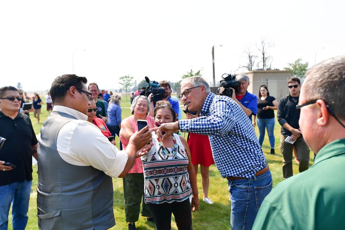 Washington Gov. Jay Inslee visits Wednesday with members of the Confederated Tribes of the Colville Reservation during a visit to survey the Chuweah Creek fire’s damage in Nespelem, Wash.  (Tyler Tjomsland/The Spokesman-Review)