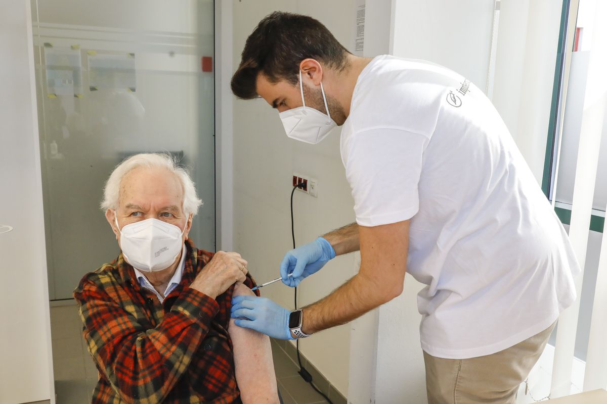 The patient Kurt Switil, left, receives a Pfizer vaccination against the COVID-19 disease by a doctor in the vaccination center ‚Am Schoepfwerk