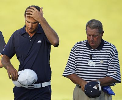 Dustin Johnson, left, walks with rules official David Price on the 18th hole during the final round of the 2010 PGA Championship. Johnson was later assessed a two-stroke penalty for grounding his club in a bunker and lost his chance at a victory. (Charlie Neibergall / Associated Press)