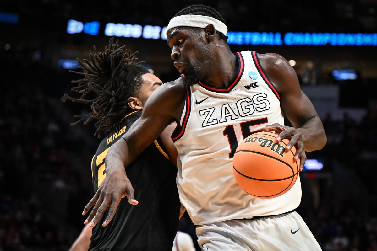 Gonzaga Bulldogs forward Graham Ike (15) moves the ball around Kennesaw State Owls forward Amir Taylor (23) during the second half of the first round of the NCAA basketball tournament on Thursday, Mar 19, 2026, at Moda Center in Portland, Ore. The Gonzaga Bulldogs won the game 73-64. (Tyler Tjomsland/The Spokesman-Review)