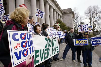 A Dino Rossi supporter, right, holds signs near a group of Gov. Chris Gregoire supporters on Dec. 13, 2004, in front of the Temple of Justice Center at the Washington state Capitol in Olympia.  (File Associated Press / The Spokesman-Review)