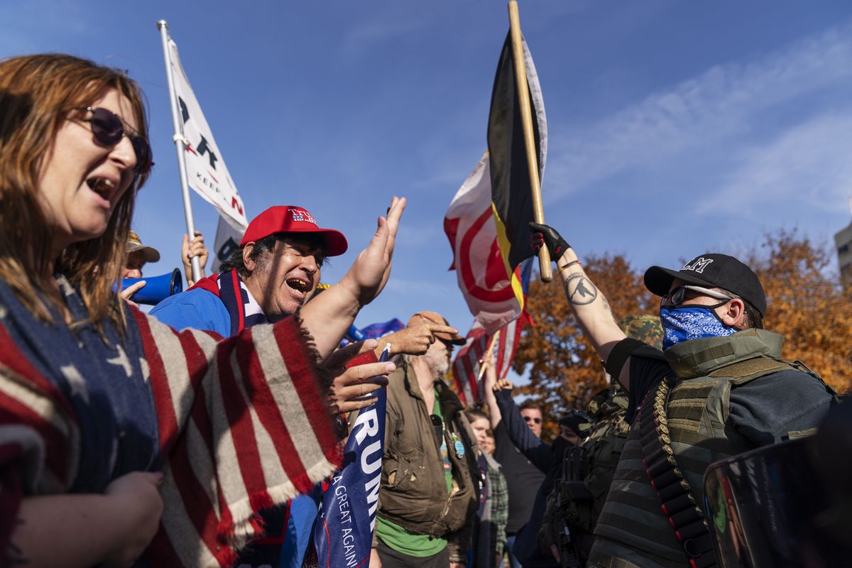Trump supporters, at left, demonstrating the election results are confronted by counter protesters at the State Capitol in Lansing, Mich., Saturday, Nov. 7, 2020. Democrat Joe Biden defeated President Donald Trump to become the 46th president of the United States on Saturday, positioning himself to lead a nation gripped by the historic pandemic and a confluence of economic and social turmoil.  (David Goldman)