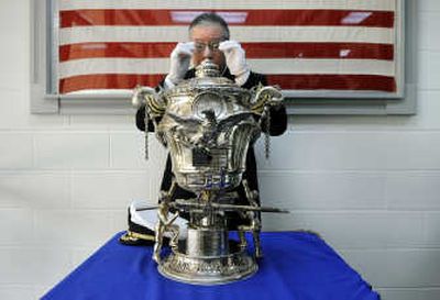 
Capt. Joseph B. Green gets a close look at the inscriptions on the 100-year-old Spokane Naval Trophy. 
 (Photos by Dan Pelle / The Spokesman-Review)