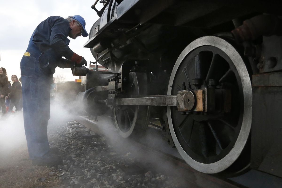 Engineer Joe Monty oils the moving parts of a steam locomotive used by the Maine Narrow Gauge Railroad for its annual runs of the Polar Express. (Robert Bukaty / Associated Press)