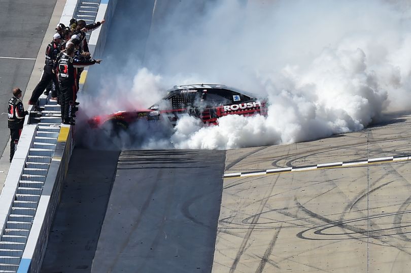 Chris Buescher, driver of the #60 Roush Performance Products Ford, is cheered by his crew while celebrating with a burnout after winning the NASCAR XFINITY Series Buckle Up 200 presented by Click It or Ticket at Dover International Speedway on May 30, 2015 in Dover, Delaware. (Photo Credit: Drew Hallowell/Getty Images) (Drew Hallowell / Getty Images North America)