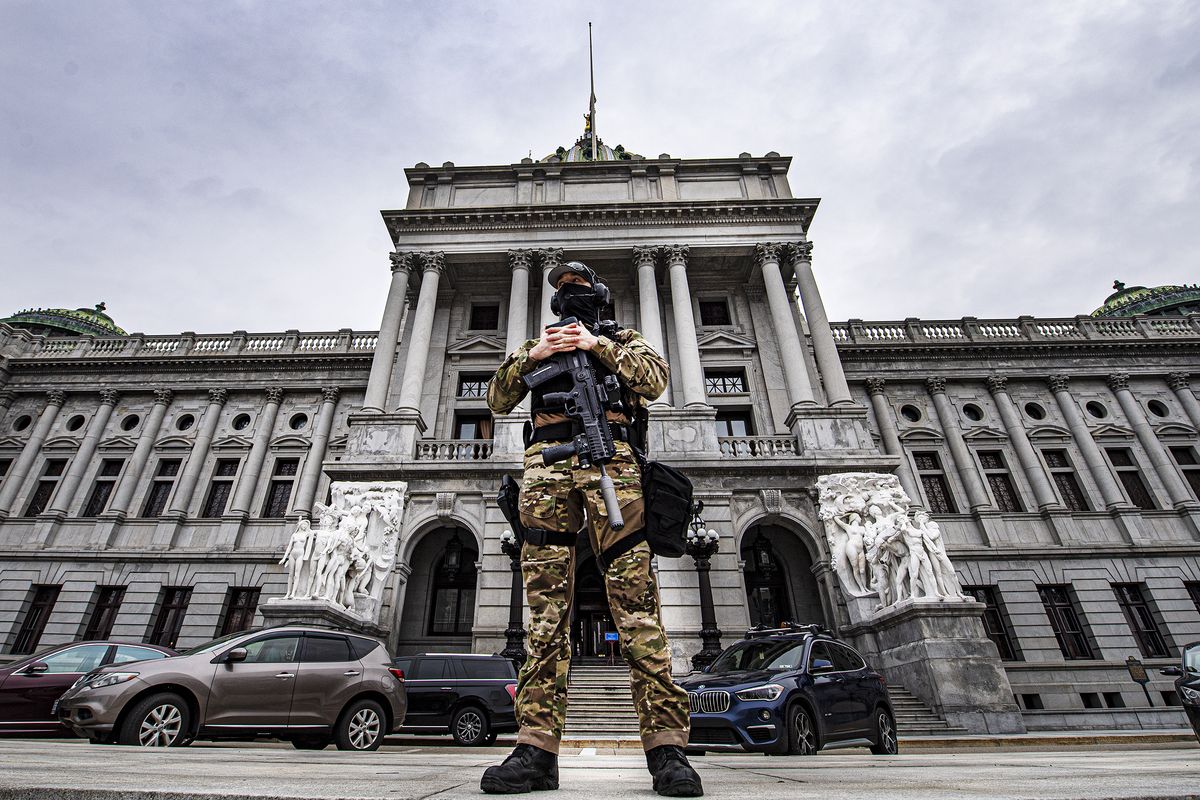 A member of the Pennsylvania Capitol Police stands guard at the entrance to the Pennsylvania Capitol Complex in Harrisburg, Pa., Wednesday, Jan. 13, 2021. State capitols across the country are under heightened security after the siege of the U.S. Capitol last week.  (Jose F. Moreno)