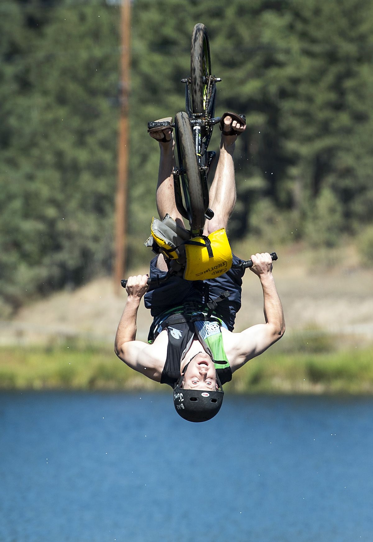 Casey Stulc, who was a Camp Reed staff member from 2006 to 2010, performs a back flip off the dock bike ramp and into Fan Lake during YMCA Camp Reed Alumni Day on Saturday. (Colin Mulvany)