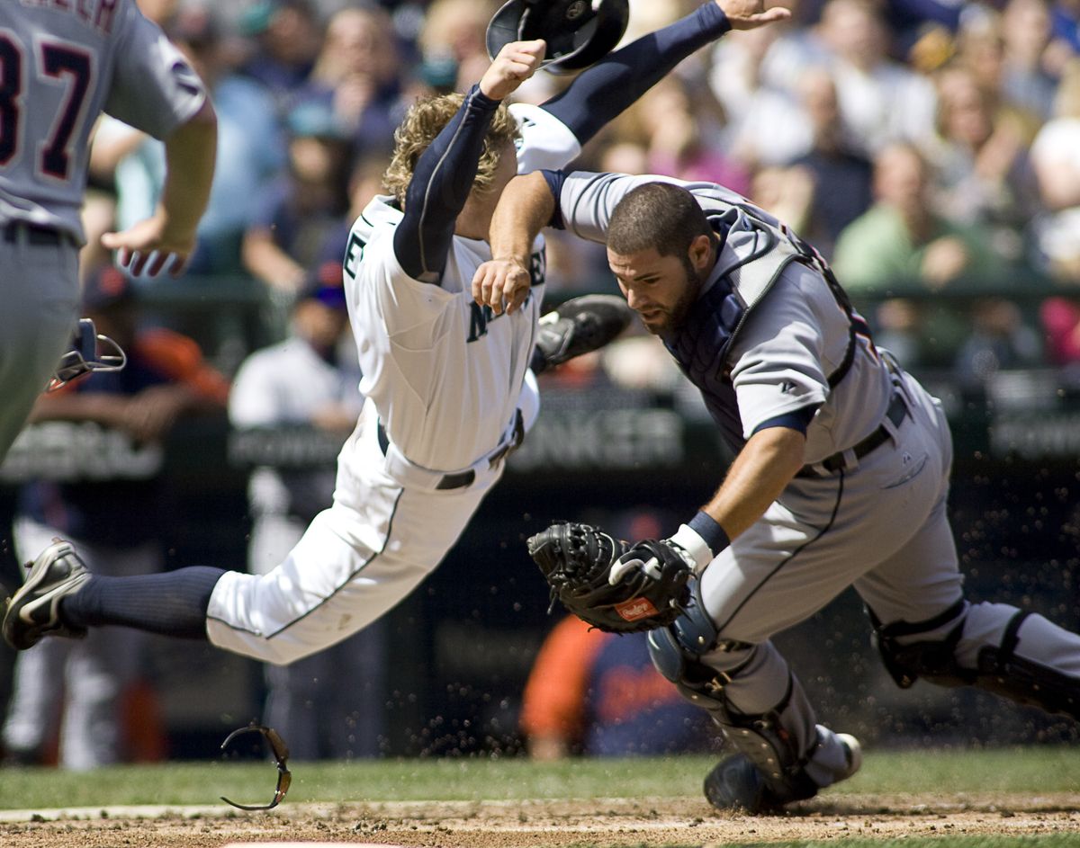 Tigers catcher Alex Avila loses his balance and his sunglasses after a collision at the plate with Seattle’s Eric Byrnes, who was out. (Associated Press)